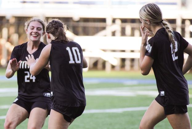 Lake Oconee Academy seniors Anika Imhof (24) and Jane Monachello (10) celebrate after a goal in Tuesday’s playoff match against Lincoln County. (WILL MORRISON/Staff)