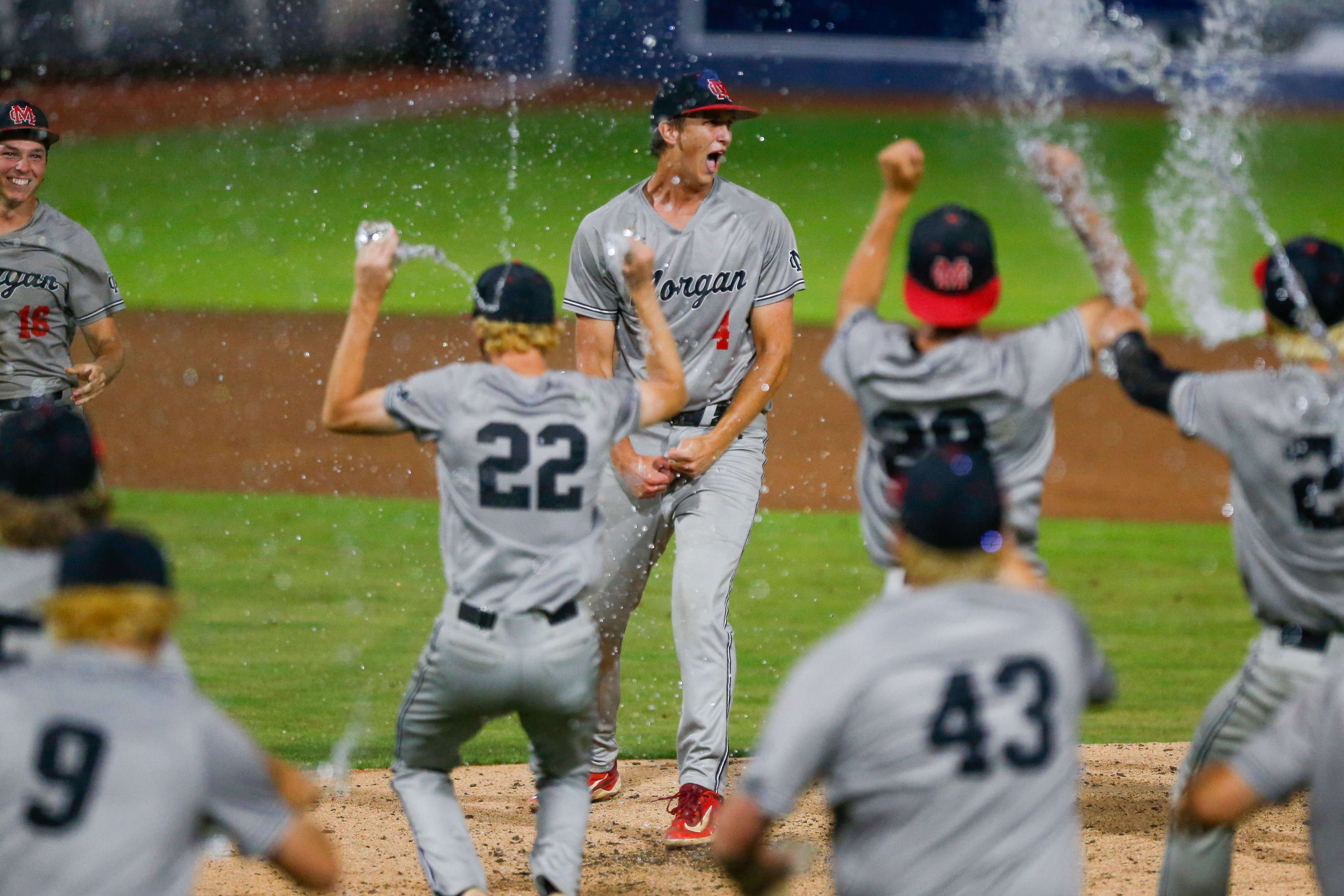 Morgan County senior Davis Strickland (4) celebrates with teammates after retiring Pierce County in order in the top of the seventh inning of Game 2, securing the state championship for the Bulldogs. LANCE MCCURLEY/Staff