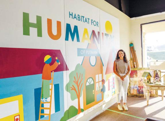 Morgan’s mural at Habitat for Humanity’s Re-Store in Putnam County. The mural features three individuals building homes. COURTESY OF GCSU