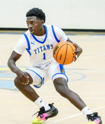 Senior CJ Taylor tries to shake off a defender and advances the ball up the court for the Titans. SKYLA MORRIS/Staff