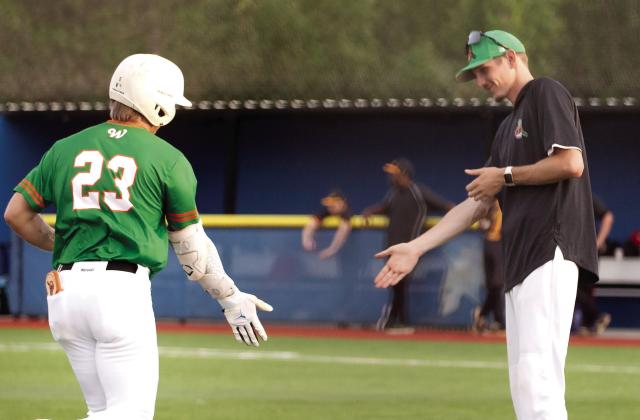 Centerfielder Caleb Riser high-fives a coaching staff member after a three-run homer batted him to home plate. SKYLA MORRIS/Staff
