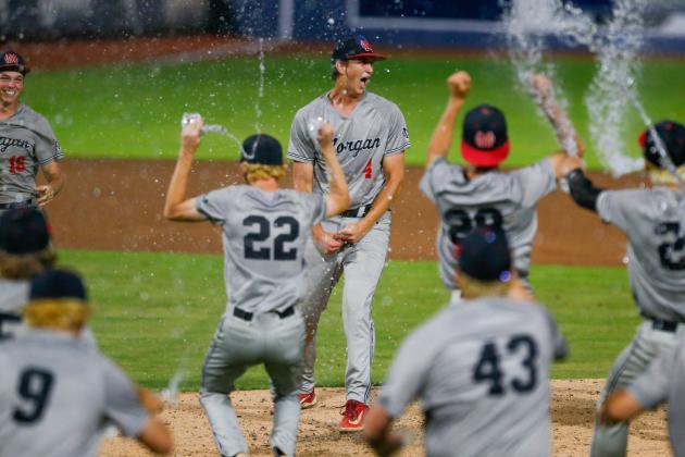 Morgan County senior Davis Strickland (4) celebrates with teammates after retiring Pierce County in order in the top of the seventh inning of Game 2, securing the state championship for the Bulldogs. LANCE MCCURLEY/Staff