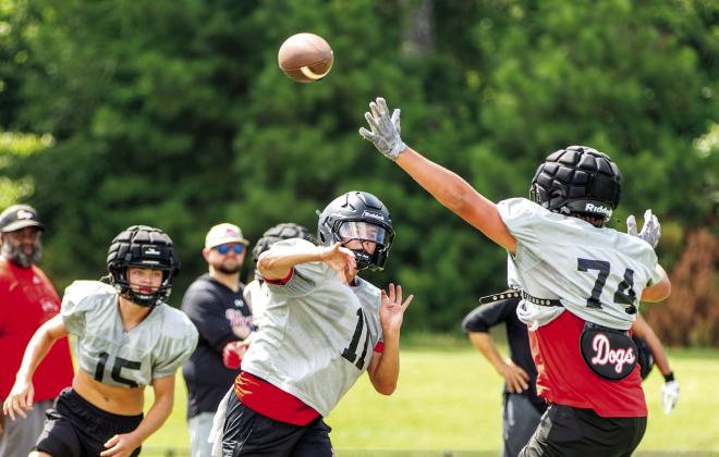 Morgan County quarterback Gunner Braswell (11) tosses a pass downfield over a defender during practice earlier this month. SKYLA MORRIS/Staff