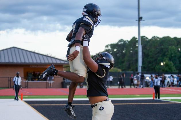 Greene County running back JaQuez Hull (left) is lifted up by a teammate after scoring a touchdown against Hancock Central on Aug. 7. LANCE McCURLEY/Staff