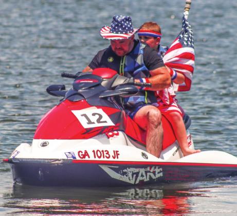 A father and son ride aboard a jet-ski during the event.