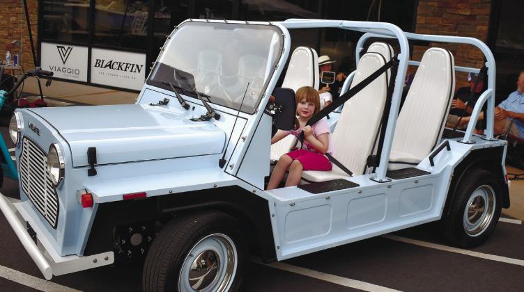 Gabby Pressley explores the Moke, just one of the electric vehicles available as a rental from Ride.  LENA HENSLEY/Staff