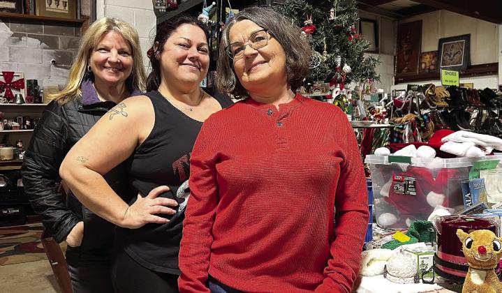 Veterans Thrift Store manager Nikki Barker (center) is flanked by employees Gina Thomason (left) and Phyllis Campbell in front of a special Christmas decorations section of the store. IAN TOCHER/Staff