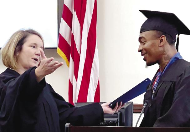 Superior Court Judge Alison Burleson welcomes Bashun Carter to the podium as he accepts his PAC graduation certificate. IAN TOCHER/Staff