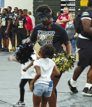 A little girl interacts with a member of the Greene County High School cheerleading team. CONTRIBUTED