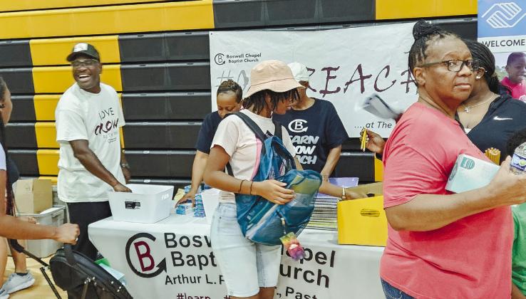 Vendors hand out school supplies to a Carson Middle School student. CONTRIBUTED