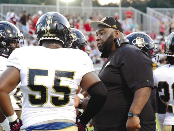 Tigers’ coach Aubrey Fortson talking with Kevin Wynn (55) and the rest of the defensive line in a game last season. LANCE McCURLEY/Staff