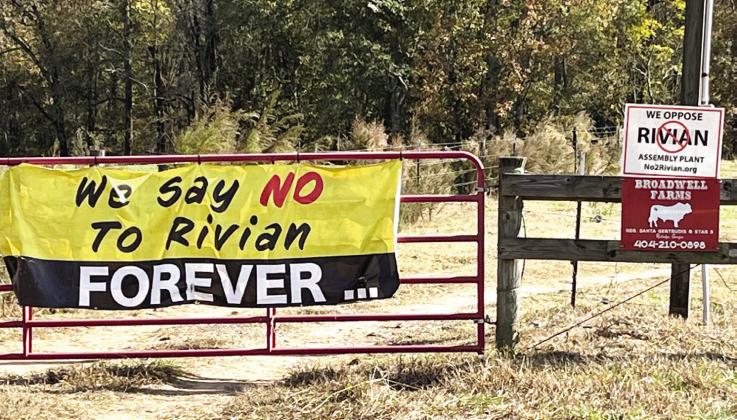 Signs near the entrance to the Rivian manufacturing site continue to show citizens’ discontent with the location of the company in rural Morgan County. MARK ENGEL/Staff