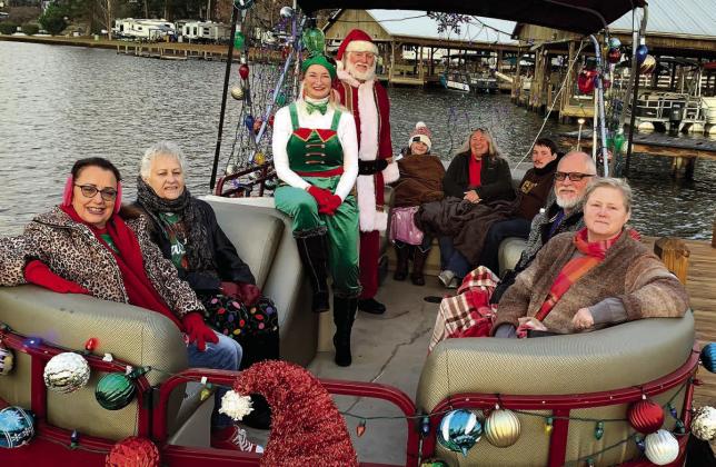 Santa and his head elf pose with cruise attendees Dec. 18 before setting out for Christmas Cove. BAILEY MCCULLY