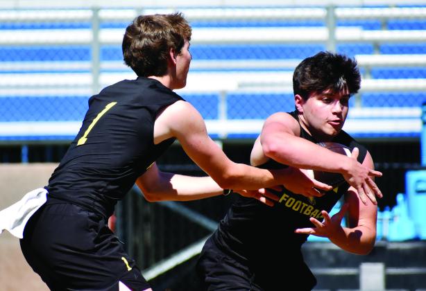 LOA quarterback Jake McDonald hands the ball off to running back Alden Barreras during a recent summer practice. CONTRIBUTED