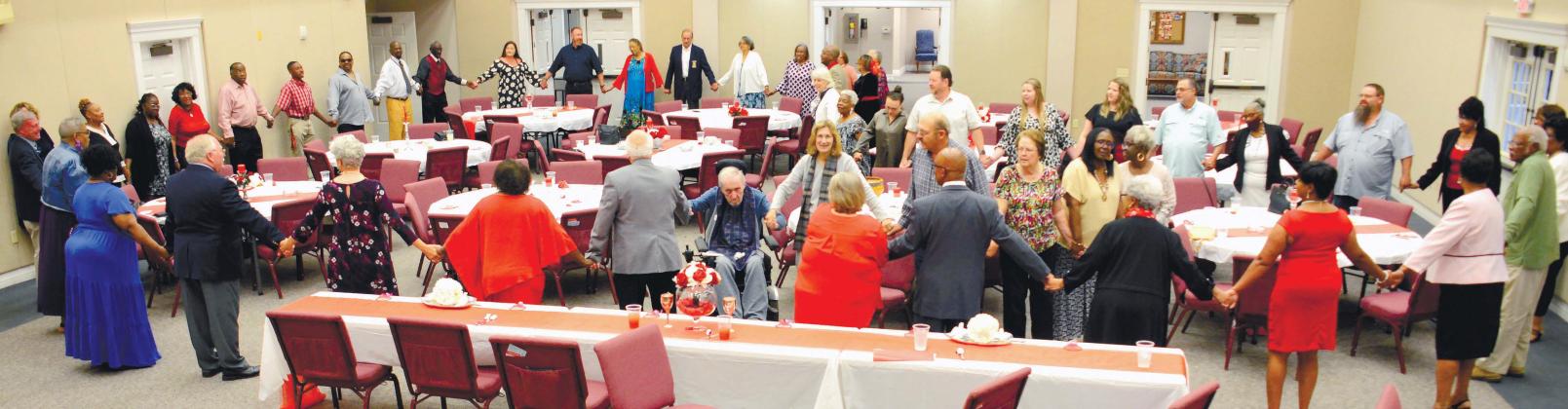 All those in attendance at the Great Hall of Eatonton’s First United Methodist Church, closed out the annual Mothers Against Crime banquet by joining hands in a closed circle and praying for Putnam County’s next generation to remain safe and succeed in life. IAN TOCHER/Staff