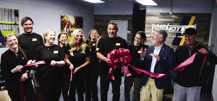 Greene County residents Dana and Dr. Pablo Santamaria (center, with scissors and bow) opened InMotion Wellness initially based on Pablo’s exposure to the benefits of targeted, assisted stretching after undergoing an operation to correct a painful back condition. IAN TOCHER/Staff