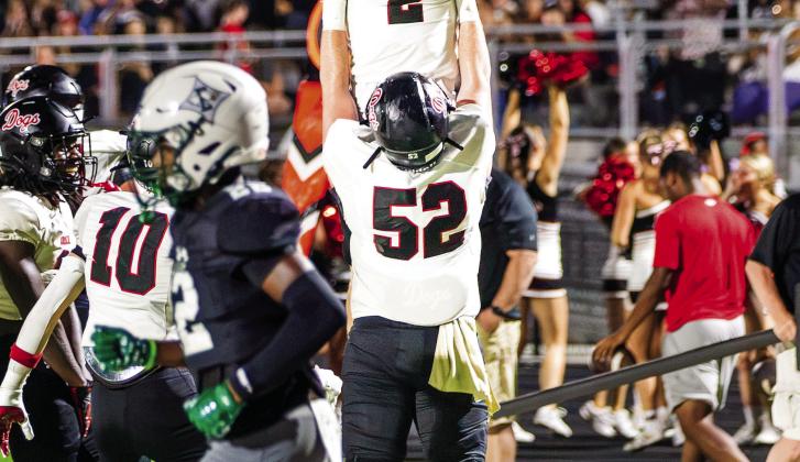 Morgan County senior offensive lineman Drew Breda (52) lifts up senior receiver Cole Wesley (2) after he scored a touchdown in last Friday’s win over Eastside. SKYLA MORRIS/Staff
