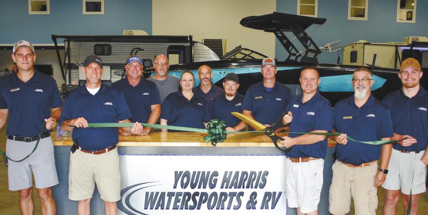 Surrounded by employees new and old, Young Harris Watersports and RVs owner Lance Markham prepares to cut the ribbon. IAN TOCHER/Staff