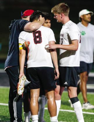 Morgan County head coach Aaron Paul hugs senior Rocco Biscoglia after the loss to the Lions. LANCE McCURLEY/Staff