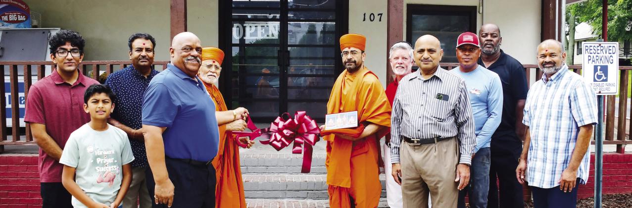Store owner Neil Patel (third from left) was joined by Eatonton Mayor John Reid (blue shirt), two “saints” from BAPS Mandir, and Eatonton-Putnam Chamber of Commerce CEO Robbie King (red shirt), among others, for a Memorial Day ribbon cutting at Stop N Go, on Eatonton’s Martin Luther King Jr. Drive. IAN TOCHER/Staff