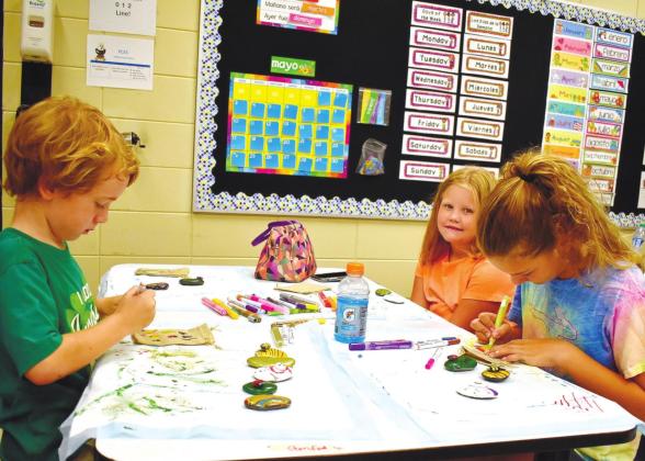 Gus Esau, Ava Kate Pope and Charlie Cummings are absorbed in the creative process. LENA HENSLEY/Staff
