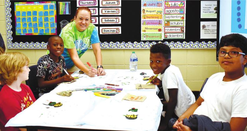 Busy painting their rocks are Logan Thomas, Noah Brown, Micah Treadwell and Joseph Ruiz under the guidance of camp instructor Candace Wooten. LENA HENSLEY/Staff