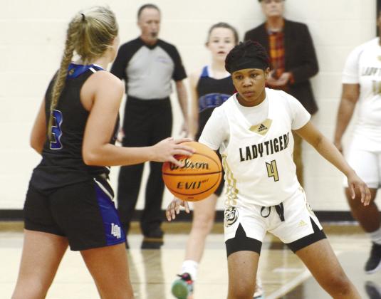 Lady Tigers’ junior Anirah Merritt (4) sets up in a zone defense eyeing down LOA junior Georgia Bosart (3), who brings the ball up the court. BRENDAN KOERNER/Staff