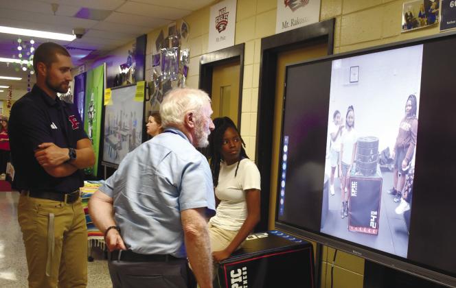 Coach Beau Beasley and student athlete Aiyana Crawford show Board of Education Chairman Dr. Steve Weiner videos of the weight training class. BAILEY BALLARD/Staff