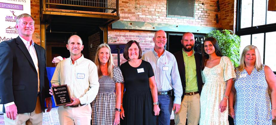 Jack’s Creek Farms Owners Damon Malcom (left) and Mark Batchelor (middle) stand alongside family members to accept the 2026 Business of the year award.