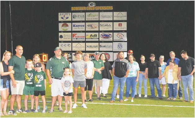 Chris Daniluk (second from left) and Clyde Harper (sixth in line) gathered with their families and friends at halftime during the Gatewood football game last Friday night, where the practice facility they built for the school was dedicated in memory of Harper’s nephew, Walt Harper. CONTRIBUTED