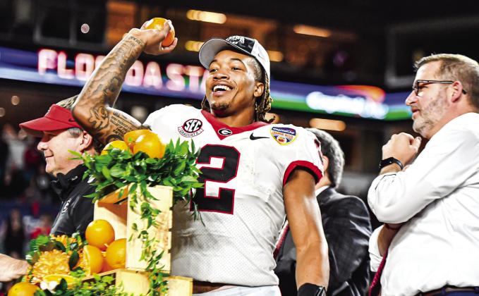 Georgia running back Kendall Milton celebrates a standout performance in the Orange Bowl, during which he carried the ball nine times for 104 yards and two touchdowns. CHARLES JORDAN/Staff
