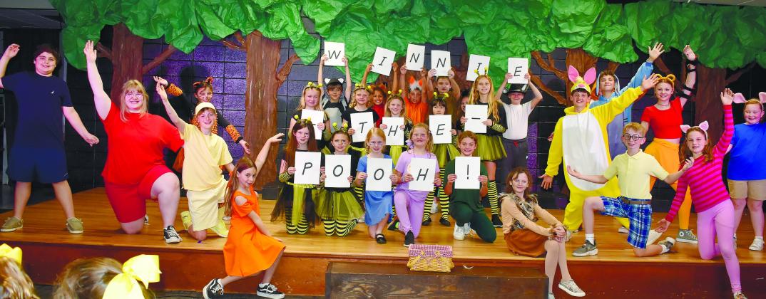 Gatewood Players show off the final scene of the play, holding up letters spelling out the name of the performance. LENA HENSLEY/Staff