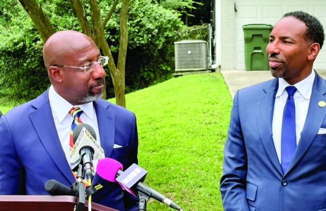 U.S. Sen. Raphael Warnock and Atlanta Mayor Andre Dickens, both Democrats, describe the impact of the bipartisan federal 21st Century ROAD to Housing Act while standing in Adamsville Drive in Southwest Atlanta on July 13. TY TAGAMI/Capitol Beat