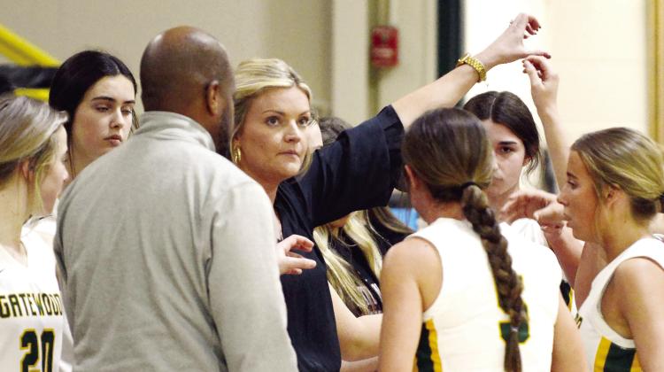 Gatewood head coach Jordan Walters steals a look at the scoreboard while counseling her Lady Gators during a recent game timeout. IAN TOCHER/Staff