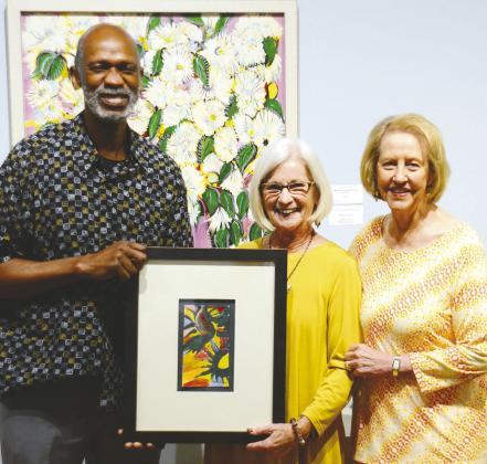 Outgoing STMA Board Member Connie Shumake (center) was clearly thrilled to also receive an original Steffen Thomas piece of art from Don Roman and Lisa Thomas Conner during the museum’s annual end-of-fiscal-year meeting.