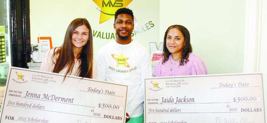Dr. Willie Oliver of Most Valuable Smiles, presented Putnam County High School graduates Jenna McDerment (left) and Jaida Jackson with $500 scholarship checks last Friday. IAN TOCHER/Staff