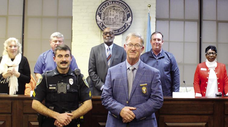 Corporal Travis Stubbs (left) receives his promotion to corporal from Madison Police Chief Bill Ashburn during the most recent council meeting. T. MICHAEL STONE/Staff