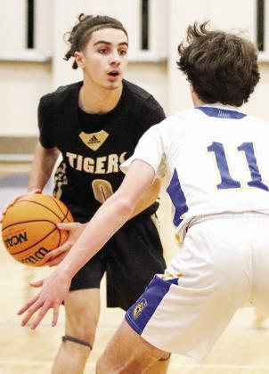 Junior Tigers guard Ryder Escbach (0) at the top of the key looking to pass the ball to a teammate. LANCE McCURLEY/Staff