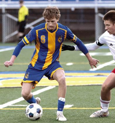 Lake Oconee Academy senior Garrett Griffin (6) dribbles the ball away from a GMC Prep defender during a home match on March 17. SKYLA MORRIS/Staff