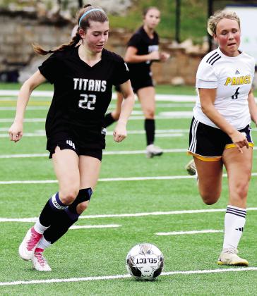 Lady Titans junior Lauren Glass (22) dribbles the ball down the field during last week’s regularseason finale against Prince Avenue Christian School. WILL MORRISON/Staff