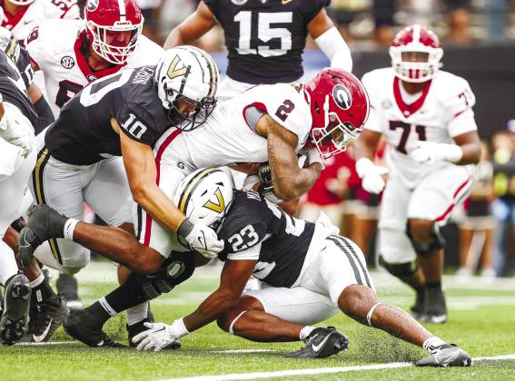 Georgia running back Kendall Milton (2) dives for extra yards as a pair of Vanderbilt defenders try and bring him down. TONY WALSH/UGA Athletics