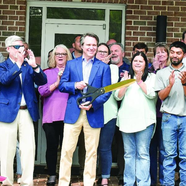 Piedmont Water owner Adam Shaifer (center) cuts the ribbon for the company’s Customer Care and Learning Center April 15 as employees, the Eatonton-Putnam Chamber of Commerce, Greene County Chamber of Commerce, and community members celebrate. HANNAH BARRON/Staff