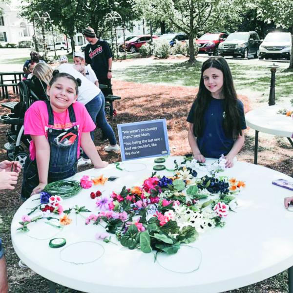 Children enjoy making flower crowns at the May Day event. CONTRIBUTED