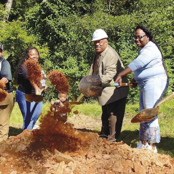 Flanked by Putnam Habitat for Humanity board member Jack McDonald and her children, Barbara Monday (second from left) was all smiles as she participated Monday in the official groundbreaking ceremony for her new home to be completed by early next spring on South Madison Street in Eatonton. IAN TOCHER/Staff