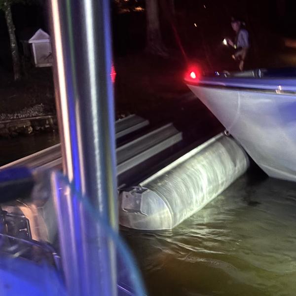 The capsized tritoon is being pushed by Putnam County Sheriff’s boats to the shore after a fireworks show on Lake Oconee July 4. (Contributed)
