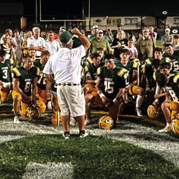 Early during the 2025 season, Gatewood head coach Jeff Ratliff (center) held court with his players, cheerleaders, and parents of both near the 50-yard line at Sammons Field in Eatonton. IAN TOCHER/Staff