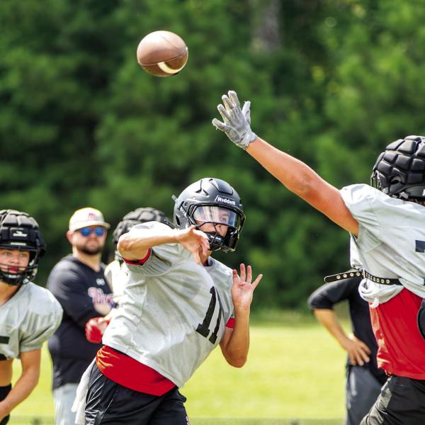 Morgan County quarterback Gunner Braswell (11) tosses a pass downfield over a defender during practice earlier this month. SKYLA MORRIS/Staff