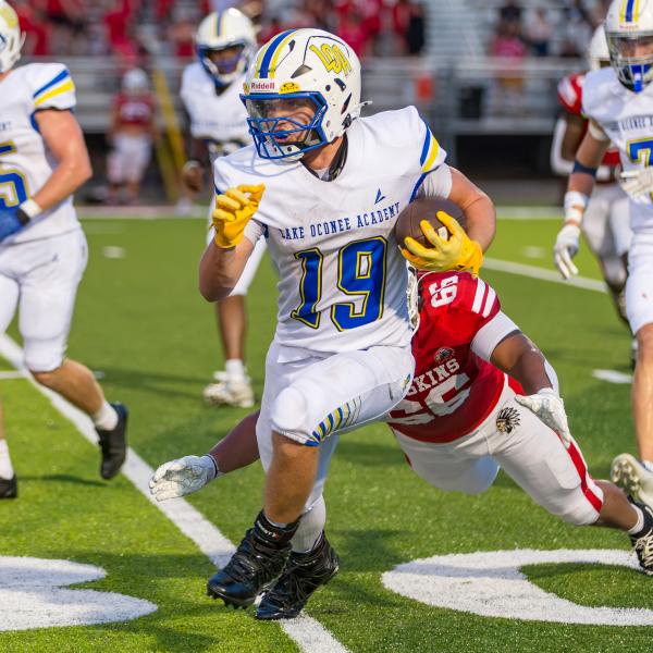 Lake Oconee Academy running back Alden Barreras (19) evades a Social Circle defender during a scrimmage against the Redskins on Aug. 14. SKYLA MORRIS/Staff
