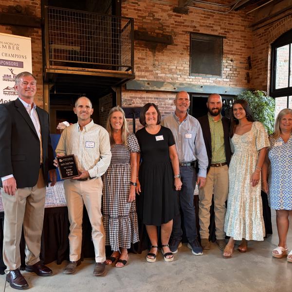 Jack’s Creek Farms Owners Damon Malcom (left) and Mark Batchelor (middle) stand alongside family members to accept the 2026 Business of the year award. SKYLA MORRIS/Staff