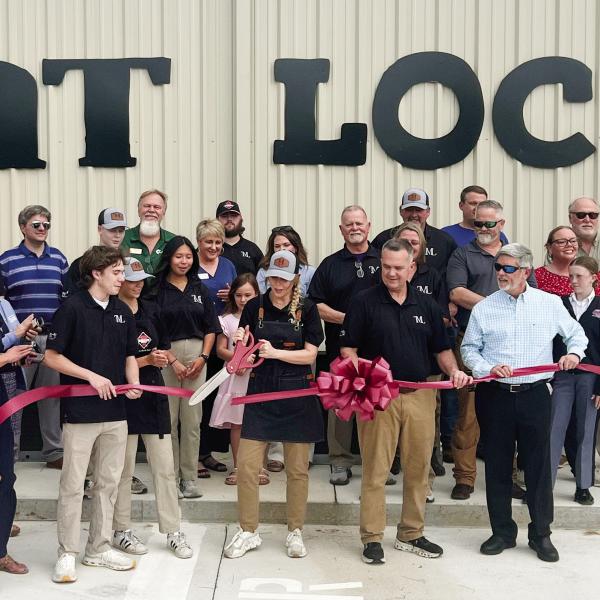 Lisa Simmons, co-owner of The Meat Locker with her husband Darin beside her, makes the official ribbon cut April 4 with Eatonton-Putnam Chamber of Commerce President Robbie King (in sunglasses) looking on. IAN TOCHER/Staff